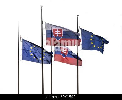 Die Flagge der Slowakei und der Europäischen Union, die auf dem Fahnenmast auf transparentem Hintergrund abgestellt ist Stockfoto