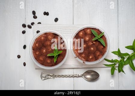 Traditioneller italienischer süßer Tiramisu-Kuchen Dessert im Glas auf weißem Holztisch Stockfoto