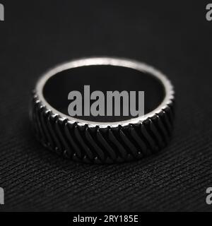 Nahaufnahme eines kreisförmigen Platinrings mit einem ordentlich geschliffenen Design, isoliert auf schwarzem Hintergrund Stockfoto