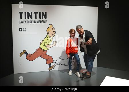 (230928) -- BRÜSSEL, 28. September 2023 (Xinhua) -- Menschen posieren für ein Selfie auf einer Ausstellung, die auf der Comic-Serie "die Abenteuer von Tintin" basiert, in Brüssel, Belgien, 27. September 2023. Die digitale Ausstellung erstreckt sich über eine 1.600 Quadratmeter große Projektionsfläche und ermöglichte es den Besuchern, in die Welt von Tintin einzutauchen. (Xinhua/Zhao Dingzhe) Stockfoto