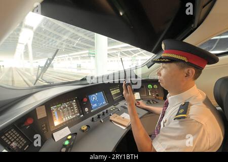 (230928) -- FUZHOU, 28. September 2023 (Xinhua) -- Chen Chengyi, der Fahrer des Fuxing-Hochgeschwindigkeitszuges G9801, macht Vorbereitungen vor der Abfahrt am Südbahnhof Fuzhou entlang der Hochgeschwindigkeitsbahn Fuzhou-Xiamen-Zhangzhou, südöstliche Provinz Fujian, 28. September 2023. Chinas schnellste Hochgeschwindigkeitsstrecke für den Seeverkehr nahm am Donnerstag den Betrieb auf, wobei die Züge mit einer Höchstgeschwindigkeit von 350 km/h entlang der Westküste der Straße von Taiwan verkehrten. Ein Fuxing-Hochgeschwindigkeitszug G9801 fuhr um 9:15 Uhr von Fuzhou, der Hauptstadt der südöstlichen chinesischen Provinz Fujian, ab und feierte die Eröffnung des 277 km langen Fuzhou-X Stockfoto