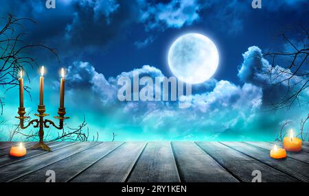 Nebel im dunklen Wald, abstrakter Halloween-Hintergrund. Rauch und Nebel auf einem alten Holztisch mit Kerzen, defokussierter Halloween-Kulisse. Stockfoto