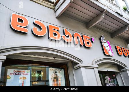 Das Zeichen für Dunkin' Donuts, das amerikanische Fast-Food-Franchise. Das Schild ist in englischer und georgischer Sprache. In Tiflis, Georgien, Europa. Stockfoto