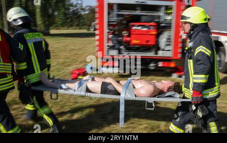 28. September 2023, Sachsen, Wiederau: Feuerwehrleute tragen einen Mann, der einen Verletzten vertritt, zur Behandlung während einer Terrorübung. Rund 150 Auszubildende des Deutschen Roten Kreuzes, Samariter und Johanniter aus Sachsen und Sachsen-Anhalt nehmen am Ende einer Trainingswoche an einer inszenierten Terrorsituation Teil. Es gab einen Angriff mit zahlreichen Opfern: Der Täter hat sich verwurzelt, Schüsse werden abgefeuert, es gibt Rauch, schwer bewaffnete und verhüllte Polizisten stürmen das Gebäude. Danach müssen die Notärzte die Verletzten behandeln. Foto: Jan Woitas/dpa Credit: dpa Picture Alliance/Alam Stockfoto