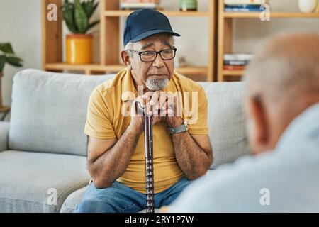 Arzt, Sprechstunde und Seniormann auf Sofa mit Gehstock oder Beratungsgespräch in der Therapie mit Psychologen. Ältere Patente, Sprechen und Stockfoto