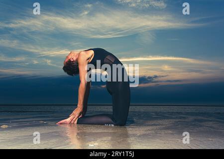 Sportliche Frau, Die Yoga Am Meer Macht Stockfoto