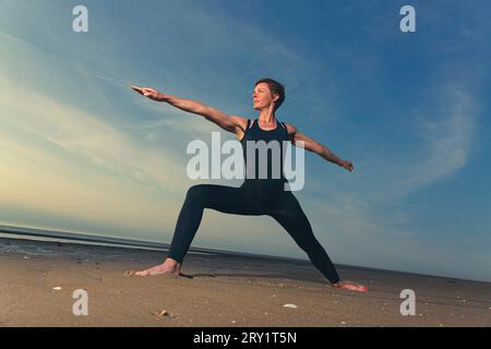 Sportliche Frau, Die Yoga Am Meer Macht Stockfoto