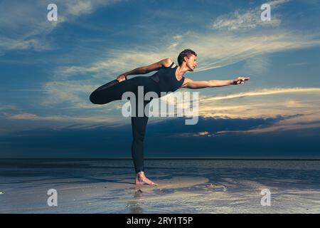 Sportliche Frau, Die Yoga Am Meer Macht Stockfoto