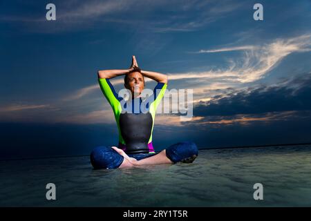 Sportliche Frau, Die Yoga Am Meer Macht Stockfoto