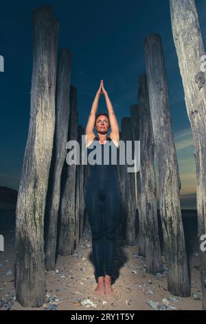 Sportliche Frau, Die Yoga Am Meer Macht Stockfoto