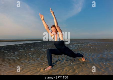 Sportliche Frau, Die Yoga Am Meer Macht Stockfoto