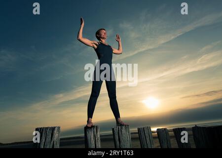 Sportliche Frau, Die Yoga Am Meer Macht Stockfoto