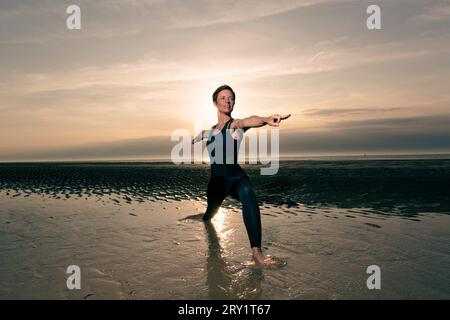 Sportliche Frau, Die Yoga Am Meer Macht Stockfoto