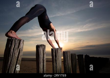 Sportliche Frau, Die Yoga Am Meer Macht Stockfoto