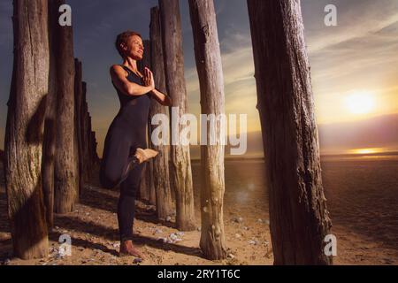 Sportliche Frau, Die Yoga Am Meer Macht Stockfoto
