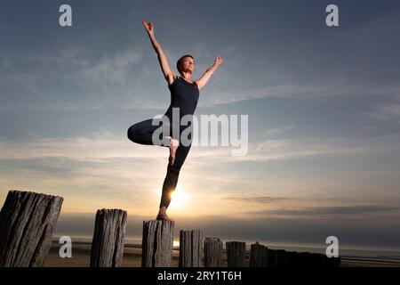 Sportliche Frau, Die Yoga Am Meer Macht Stockfoto