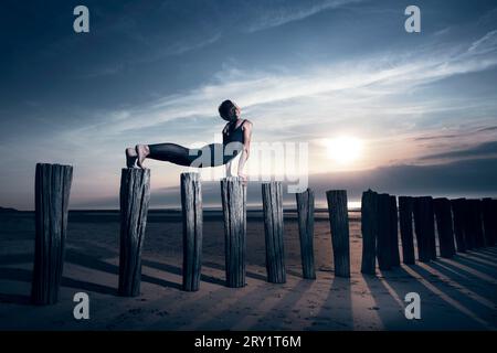 Sportliche Frau, Die Yoga Am Meer Macht Stockfoto