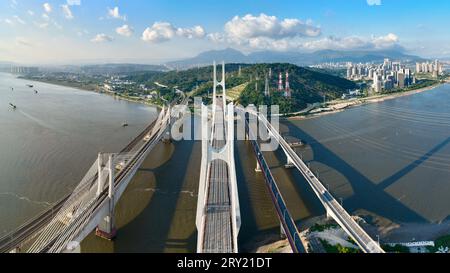 FUZHOU, 28. September 2023 (Xinhua) -- dieses Luftbild vom 26. September 2023 zeigt die Wulong River Bridge (C) entlang der Fuzhou-Xiamen-Zhangzhou Hochgeschwindigkeitsbahn in der südöstlichen chinesischen Provinz Fujian. Chinas schnellste Hochgeschwindigkeitsstrecke für den Seeverkehr nahm am Donnerstag den Betrieb auf, wobei die Züge mit einer Höchstgeschwindigkeit von 350 km/h entlang der Westküste der Straße von Taiwan verkehrten. Ein Fuxing-Hochgeschwindigkeitszug G9801 fuhr um 9:15 Uhr von Fuzhou, der Hauptstadt der südöstlichen chinesischen Provinz Fujian, ab und feierte die Eröffnung der 277 km langen Hochgeschwindigkeitsbahn Fuzhou-Xiamen-Zhangzhou. Das ist das erste Mal in China Stockfoto