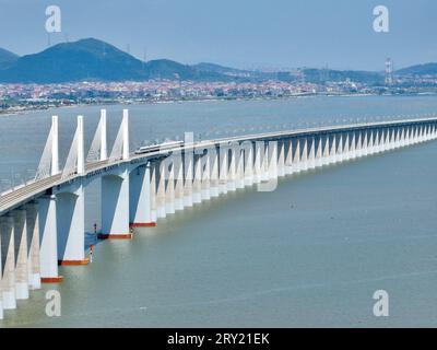 (230928) -- FUZHOU, 28. September 2023 (Xinhua) -- dieses Luftbild vom 19. September 2023 zeigt die Meizhou Bay-Überseebrücke entlang der Fuzhou-Xiamen-Zhangzhou-Hochgeschwindigkeitsbahn in der südöstlichen chinesischen Provinz Fujian. Chinas schnellste Hochgeschwindigkeitsstrecke für den Seeverkehr nahm am Donnerstag den Betrieb auf, wobei die Züge mit einer Höchstgeschwindigkeit von 350 km/h entlang der Westküste der Straße von Taiwan verkehrten. Ein Fuxing-Hochgeschwindigkeitszug G9801 fuhr um 9:15 Uhr von Fuzhou, der Hauptstadt der südöstlichen chinesischen Provinz Fujian, ab und feierte die Eröffnung der 277 km langen Hochgeschwindigkeitsbahn Fuzhou-Xiamen-Zhangzhou. Das gehört China Stockfoto