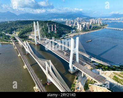 FUZHOU, 28. September 2023 (Xinhua) -- dieses Luftbild vom 26. September 2023 zeigt die Wulong River Bridge (C) entlang der Fuzhou-Xiamen-Zhangzhou Hochgeschwindigkeitsbahn in der südöstlichen chinesischen Provinz Fujian. Chinas schnellste Hochgeschwindigkeitsstrecke für den Seeverkehr nahm am Donnerstag den Betrieb auf, wobei die Züge mit einer Höchstgeschwindigkeit von 350 km/h entlang der Westküste der Straße von Taiwan verkehrten. Ein Fuxing-Hochgeschwindigkeitszug G9801 fuhr um 9:15 Uhr von Fuzhou, der Hauptstadt der südöstlichen chinesischen Provinz Fujian, ab und feierte die Eröffnung der 277 km langen Hochgeschwindigkeitsbahn Fuzhou-Xiamen-Zhangzhou. Das ist das erste Mal in China Stockfoto