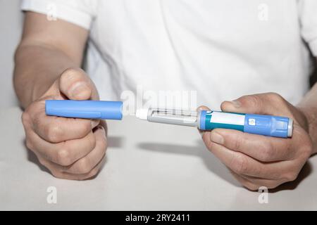 Weibliche Hände, die einen Insulinpen halten. Ozempic Insulin-Injektions-Pen oder Insulin-Patronen-Pen für Diabetiker. Medizinische Geräte für Diabeteskranke. Stockfoto