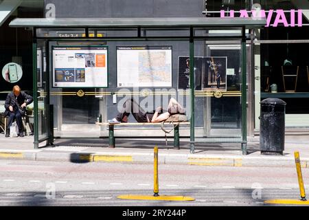 Ein Mann, der in einer Bushaltestelle vor dem zentralen Busbahnhof in Stockholm, Schweden, schläft. Foto: Rob Watkins Stockfoto