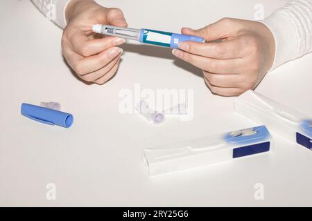 Weibliche Hände, die einen Insulinpen halten. Ozempic Insulin-Injektions-Pen oder Insulin-Patronen-Pen für Diabetiker. Medizinische Geräte für Diabeteskranke. Stockfoto