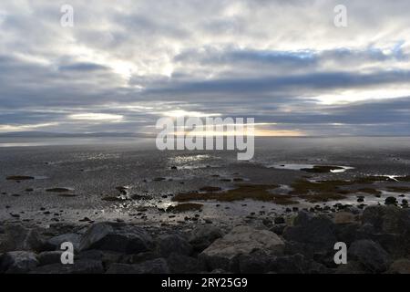 Bei Ebbe blickt man über die Bucht von Morecambe, und die Crepuskularstrahlen strahlen vom Morgenhimmel aus. Stockfoto