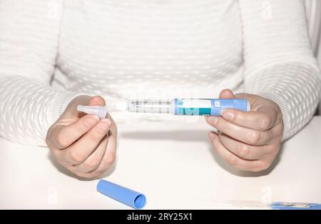 Weibliche Hände, die einen Insulinpen halten. Ozempic Insulin-Injektions-Pen oder Insulin-Patronen-Pen für Diabetiker. Medizinische Geräte für Diabeteskranke. Stockfoto