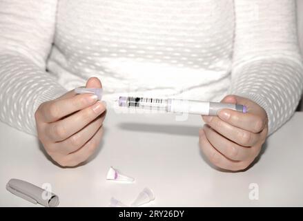 Weibliche Hände, die einen Insulinpen halten. Ozempic Insulin-Injektions-Pen oder Insulin-Patronen-Pen für Diabetiker. Medizinische Geräte für Diabeteskranke. Stockfoto