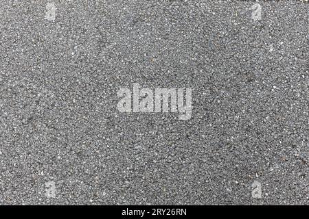 Dunkler texturierter Asphaltschwarzer Hintergrund, Oberflächenschleifen rauer Asphalt, nahtlose Asphaltdecke dunkelgraue körnige Straße, Texturhintergrund. Stockfoto