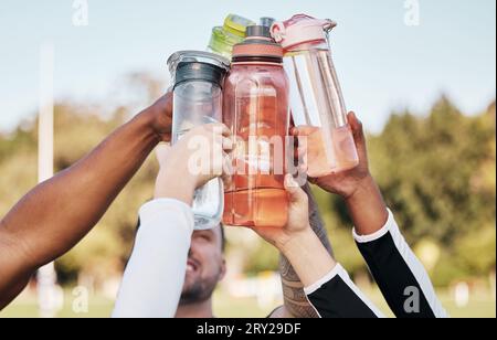 Hände, Wasserflasche und Jubel für Teamsport, Fitness oder Training im Freien auf dem Rasen. Diversität Sport Menschen, gesundes Cardio-Workout Stockfoto