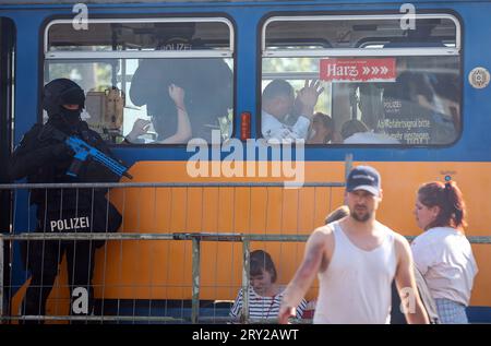 28. September 2023, Sachsen, Wiederau: Polizeibeamte sichern während einer Terrorübung eine Straßenbahn. Rund 150 Auszubildende des Deutschen Roten Kreuzes, Samariter und Johanniter aus Sachsen und Sachsen-Anhalt nehmen am Ende einer Trainingswoche an einer inszenierten Terrorsituation Teil. Es gab einen Angriff mit zahlreichen Opfern: Der Täter hat sich verwurzelt, Schüsse werden abgefeuert, es gibt Rauch, schwer bewaffnete und verhüllte Polizisten stürmen das Gebäude. Danach müssen die Notärzte die Verletzten behandeln. Foto: Jan Woitas/dpa Stockfoto