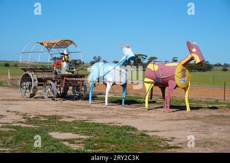 Eine Metallskulptur mit Pferden und einer Kutsche mit einem Fahrer und Hunden auf dem Tin Horse Highway in der Nähe von Kulin, Wheatbelt Region, Western Australia. Stockfoto