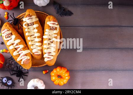 Lustige Mumie Hot Dogs für Halloween Party oder Kinder Urlaub Brunch. Klassische Hot Dogs mit Käseaugen und käsiger Mayo-Sauce, mit Halloween-Dekor, Top VI Stockfoto