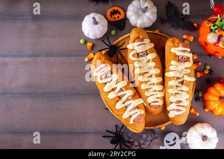 Lustige Mumie Hot Dogs für Halloween Party oder Kinder Urlaub Brunch. Klassische Hot Dogs mit Käseaugen und käsiger Mayo-Sauce, mit Halloween-Dekor, Top VI Stockfoto