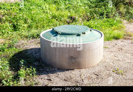 Überdachter Kanalschacht des ländlichen Klärtanks mit grüner Kunststoffabdeckung, Abwassersystem. Kanalisationsnetze für Landhäuser. Sanitärkanalsystem Manhol Stockfoto