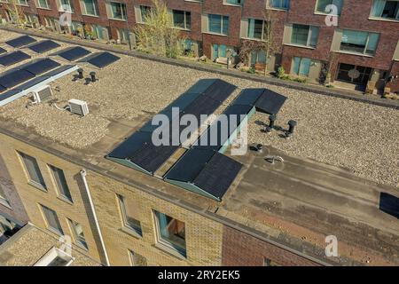 Blick aus der Vogelperspektive auf das moderne Viertel mit Solarpaneelen auf dem Dach von Wohngebäuden an sonnigen Tagen Stockfoto