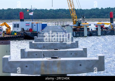 28. September 2023, Mecklenburg-Vorpommern, Prerow: Kräne und Bagger auf Arbeitsbooten arbeiten auf dem Pier zum zukünftigen Inselhafen in der Ostsee. Der Inselhafen soll den Schutzhafen auf der Halbinsel Fischland-Darß-Zingst ersetzen, der am 15. Oktober 2023 endgültig geschlossen werden soll. Der Bau der künstlichen Insel und des 720 Meter langen Pier, der längste im Ostseeraum, begann vor etwas mehr als einem Jahr und soll rund 42 Millionen Euro Kosten und für die Wassersportsaison 2024 in Betrieb genommen werden. Im Plan hat der Inselhafen eine tropfenförmige Form Stockfoto