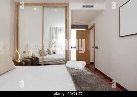 Ein Doppelzimmer mit eingebautem Kleiderschrank mit Spiegelschiebetüren Stockfoto