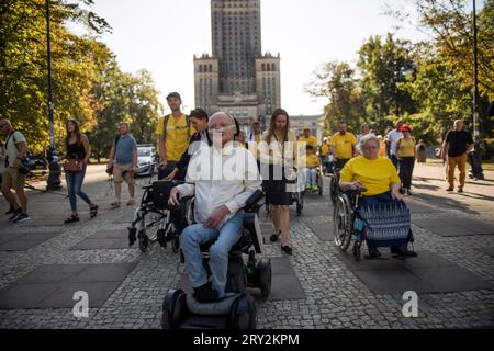 Warschau, Polen - 28. September 2023 Lukasz Krason, Kandidat der Partei Polen 2050 für die Parlamentswahlen, führt den märz "Wir sind alle GLEICH WICHTIG" an. Ein von der politischen Partei Polska 2050 (Polska 2050) unter dem Motto "Wir sind alle GLEICH WICHTIG" (Wszyscy Jestemy ROWNOWAZNI) unter der Leitung von Lukasz Krason organisierter marsch führte durch die Straßen von Warschau. Die Teilnehmer trugen gelbe T-Shirts (Farbe der Party); einige von ihnen schoben leere Kinderwagen, um Menschen zu symbolisieren, die in Zukunft Behinderungen erleben könnten. „Menschen mit Behinderungen wollen ein System, das ihnen hilft Stockfoto