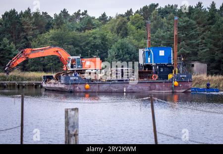 28. September 2023, Mecklenburg-Vorpommern, Prerow: Am Notfallhafen Darßer Ort im Nationalpark Vorpommersche Boddenlandschaft werden schwere Geräte zum Abreißen von Stegen und Betonflächen und zur Vorbereitung der Renaturierung des Gebietes eingesetzt. Der Hafen wurde Anfang der 1960er Jahre gegen bestehende Naturschutzgesetze an der zuvor unberührten Küste errichtet. Lange Zeit diente er als Küstenhafen für Torpedoschnellboote der DDR-Volksmarine und nach der Wiedervereinigung als Zufluchtsort und Standort für einen Rettungskreuzer der Deutschen Seesuche- und Rettungsdienste (DGZ) Stockfoto