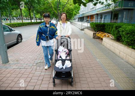 Peking, China - 6. Mai 2023: Zwei Damen schlendern mit ihren Kinderwagen im Park. Stockfoto