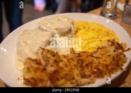 Frühstück mit Rühreiern, Biscuits & Gravy (Brötchen mit Soße) Stockfoto