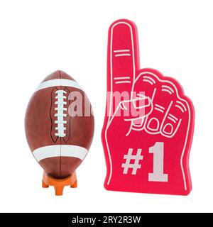 Ein American Football mit weißem Streifen, der für College- und Highschool-Fußballspiele verwendet wird, auf einem orangefarbenen T-Stück zusammen mit einem roten Schaum 1 Finger. Stockfoto
