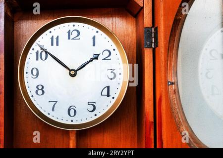 Alte Vintage-Uhr auf einem hölzernen Hintergrund. Rundes Zifferblatt der Wanduhr. Konzeptzeit läuft. Zeitkonzept. Uhr, Uhr, Timer, Zeitmesser, Ticke Stockfoto