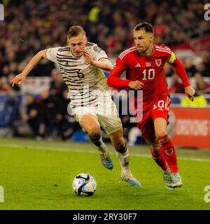 Cardiff, Wales - 28. März 2023: Der walisische Aaron Ramsey fühlt sich während der UEFA-Europameisterschaft der Gruppe D unter Druck von Kristers Tobers Stockfoto