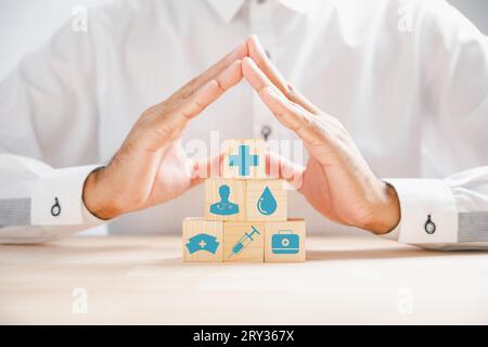 Arzthand auf einem Holzwürfelblock mit Schutzschild Stockfoto