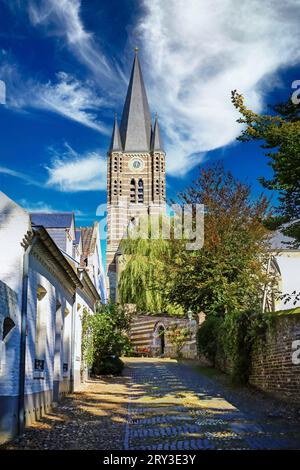 Idyllische enge alte Gasse in einem kleinen niederländischen Dorf mit mittelalterlichem Kirchturm - Thorn, Limburg, Niederlande Stockfoto