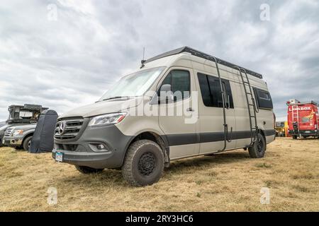 Loveland, CO, USA - 25. August 2023: Mercedes Sprinter Wohnmobil mit Dachleiter und Surfboard- oder Paddleboard-Regalen. Stockfoto